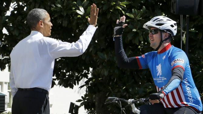 Obama cheers on a participant in the Wounded Warrior Project's Soldier Ride as they begin a 3-day ride to raise awareness for injured veterans with two laps around the South Lawn at the White House in Washington