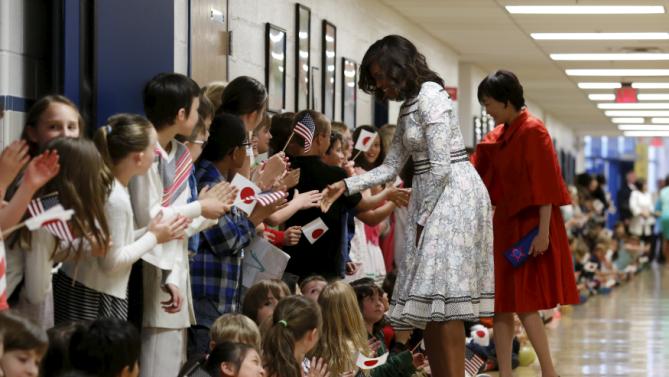 U.S. First Lady Michelle Obama and Mrs. Akie Abe, wife of Japanese Prime Minister Shinzo Abe, are greeted by students at Great Falls Elementary School