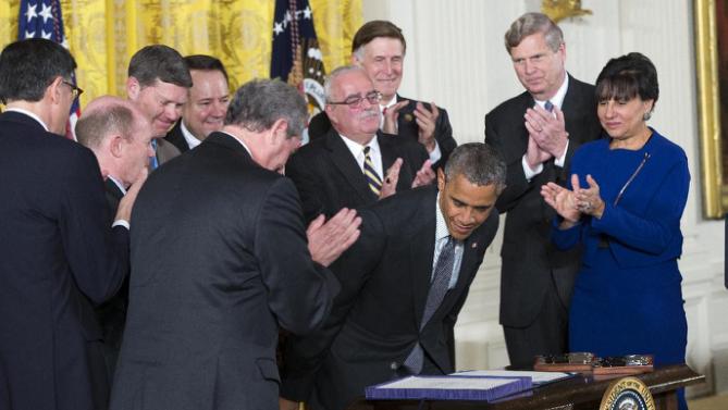 Law makers and cabinet officials applaud President Barack Obama after he signed H.R. 2146 Defending Public Safety Employees Retirement Act and H.R. 1295 Trade Preferences Extension Act of 2015, Monday, June 29, 2015, in the East Room of the White House in Washington. The president signed into law two hard-fought bills giving him greater authority to negotiate international trade deals and providing aid to workers whose jobs are displaced by such pacts. Commerce Secretary Penny Pritzker is at right.  (AP Photo/Evan Vucci)