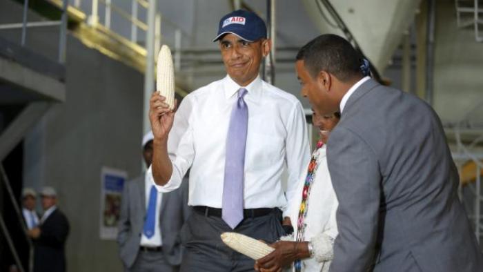 U.S. President Barack Obama (L) shows off a ear of corn grown by a farmer (2nd R) participating in the Feed the Future program as he tours the Faffa Food factory in Addis Ababa, Ethiopia July 28, 2015. Obama told Ethiopia's leaders on Monday that allowing more political freedoms would strengthen the African nation, which had already lifted millions out of a poverty once rooted in recurring famine. REUTERS/Jonathan Ernst