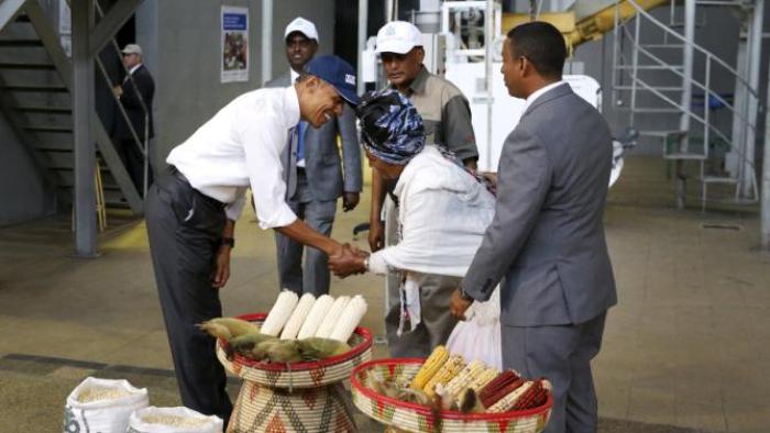U.S. President Barack Obama (L) bows deeply as he greets a farmer (front C) participating in the Feed the Future program as he tours the Faffa Food factory in Addis Ababa, Ethiopia July 28, 2015. Obama told Ethiopia's leaders on Monday that allowing more political freedoms would strengthen the African nation, which had already lifted millions out of a poverty once rooted in recurring famine. REUTERS/Jonathan Ernst
