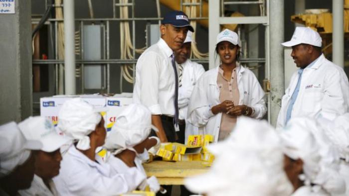 U.S. President Barack Obama (C) looks on as workers demonstrate part of the packaging process as he tours the Faffa Food factory in Addis Ababa, Ethiopia July 28, 2015. Obama told Ethiopia's leaders on Monday that allowing more political freedoms would strengthen the African nation, which had already lifted millions out of a poverty once rooted in recurring famine. REUTERS/Jonathan Ernst