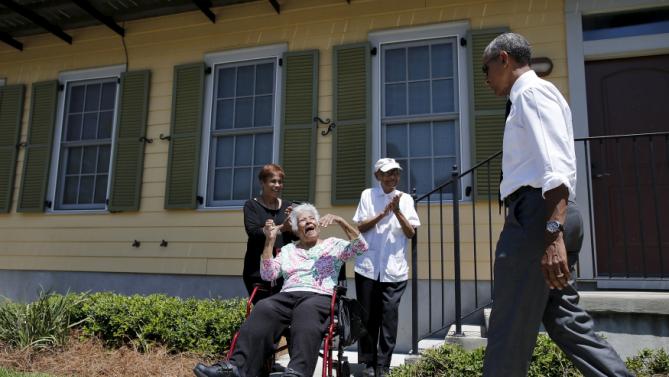 U.S. President Barack Obama is welcomed by local residents of an area reconstructed after Hurricane Katrina during a presidential visit to New Orleans, Louisiana, August 27, 2015. Obama on Thursday will highlight the "structural inequality" that hurt poor black people in New Orleans before the devastation of Hurricane Katrina, during a visit to celebrate the city's progress 10 years after the storm. REUTERS/Carlos Barria