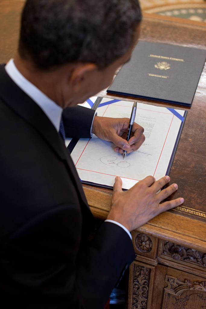 President Barack Obama signs H.R. 2097, the Star-Spangled Banner Commemorative Coin Act, at the Resolute Desk in the Oval Office, Aug. 16, 2010. (Official White House Photo by Pete Souza) This official White House photograph is being made available only for publication by news organizations and/or for personal use printing by the subject(s) of the photograph. The photograph may not be manipulated in any way and may not be used in commercial or political materials, advertisements, emails, products, promotions that in any way suggests approval or endorsement of the President, the First Family, or the White House.