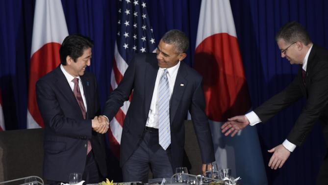 U.S. President Barack Obama, center, gets caught in his chair as he stands to shake hands with Japans Prime Minister Shinzo Abe, left, during a bilateral meeting at the Asia-Pacific Economic Cooperation summit in Manila, Philippines, Thursday, Nov. 19, 2015. (AP Photo/Susan Walsh)