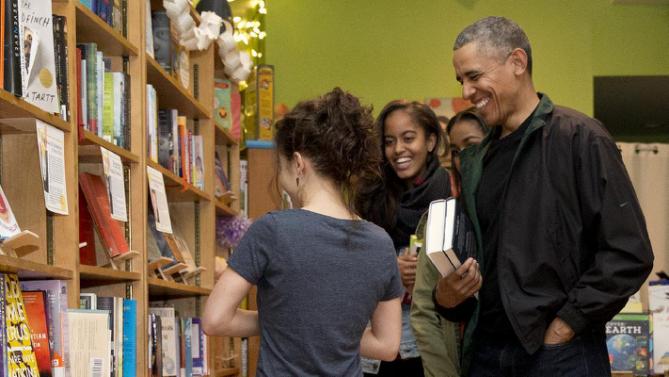 President Barack Obama, right, joined by his daughters Malia, second from left, and Sasha, second from right, talk with manager Anna Thorn, left, as they shop at Upshur Street Books on Small Business Saturday in Washington, Saturday, Nov. 28, 2015. (AP Photo/Carolyn Kaster)