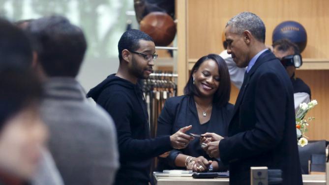 U.S. President Barack Obama (R) uses a credit card to buy an item at the Shinola watchmakers flagship store in Detroit, Michigan January 20, 2016. REUTERS/Jonathan Ernst