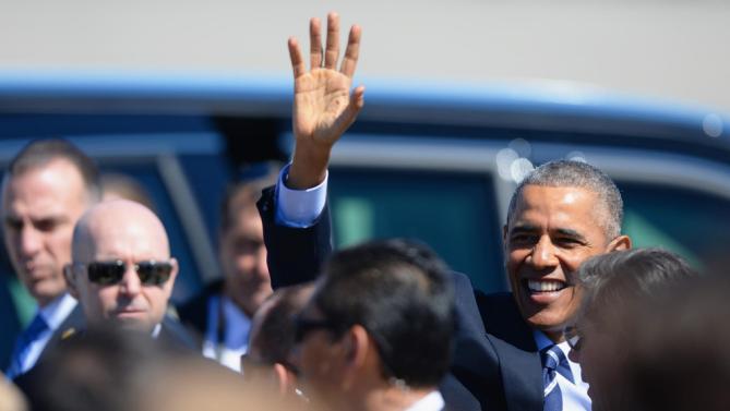 President Barack Obama waves to supporters on the tarmac after arriving on Air Force One at Cecil Airport in Jacksonville, Fla., Friday, Feb. 26, 2016, to visit Saft America factory, which opened in 2011 with help from federal money from economic stimulus package he pushed through Congress in 2009. (AP Photo/Rick Wilson)