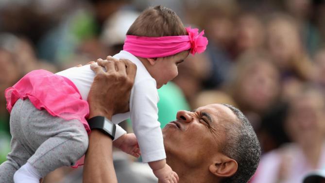 President Barack Obama holds up Stella Muñoz in the air as he visits children at the egg roll station of the White House Easter Egg Roll at the White House in Washington, Monday, March 28, 2016. Thousands of children gathered at the White House for the annual Easter Egg Roll. This year's event features live music, sports courts, cooking stations, storytelling, and Easter egg rolling. (AP Photo/Andrew Harnik)