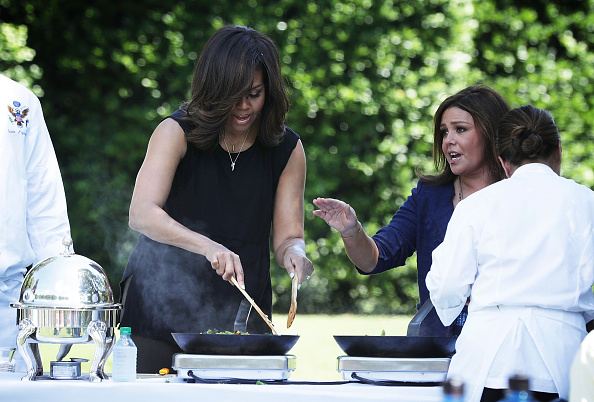 WASHINGTON, DC - JUNE 06: U.S. first lady Michelle Obama (L) and TV host Rachael Ray (R) cook ingredients from a White House Kitchen Garden harvest June 6, 2016 at the White House in Washington, DC. The first lady welcomed back students from the kitchen garden planting earlier in spring to help the harvest today. (Photo by Alex Wong/Getty Images)