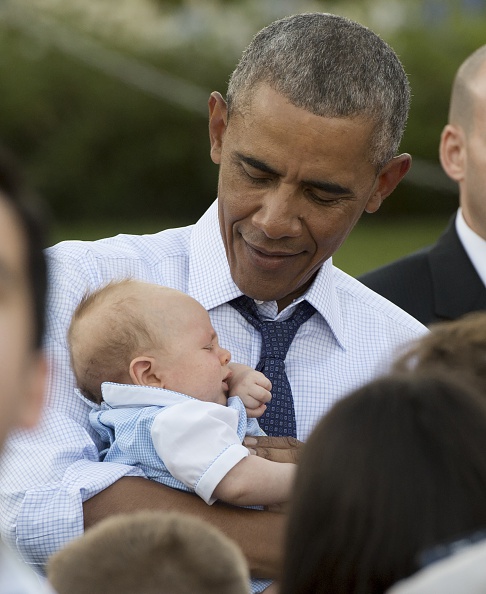 US President Barack Obama holds a baby as he greets guests during a picnic for members of Congress on the South Lawn of the White House in Washington, DC, June 14, 2016. / AFP / SAUL LOEB (Photo credit should read SAUL LOEB/AFP/Getty Images)