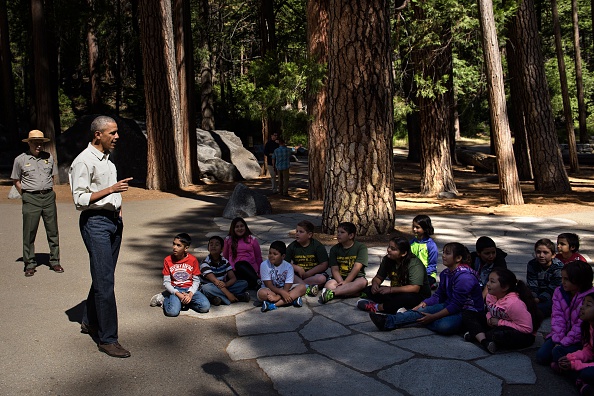 US President Barack Obama speaks to children about the "Every Kid in the Park" initiative in Yosemite National Park, California, while celebrating the 100th year of US National Parks June 18, 2016. / AFP / Brendan Smialowski (Photo credit should read BRENDAN SMIALOWSKI/AFP/Getty Images)