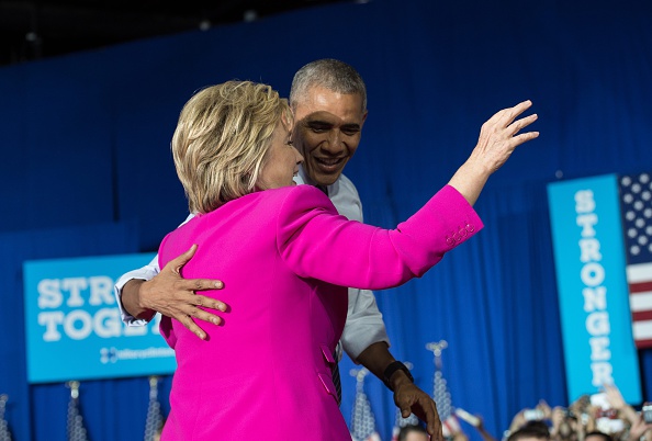 US President Barack Obama and Democratic presidential candidate Hillary Clinton leave a campaign event in Charlotte, North Carolina, on July 5, 2016. US President Barack Obama threw his full weight behind Hillary Clinton's bid to succeed him, extolling the experience and fighting spirit of his former secretary of state at their first joint campaign appearance. "I'm here today because I believe in Hillary Clinton," Obama told the rally in Charlotte, North Carolina. "There has never been any man or woman more qualified for this office." / AFP / NICHOLAS KAMM (Photo credit should read NICHOLAS KAMM/AFP/Getty Images)