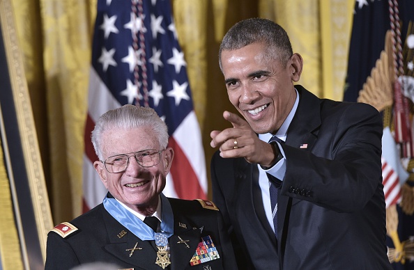 US President Barack Obama points to cameras after presenting the Medal of Honor to retired US Army Lt. Colonel Charles Kettles during a ceremony in the East Room of the White House on July 18, 2016 in Washington, DC. Lt. Colonel Kettles was awarded the Medal of Honor for conspicuous gallantry while serving in Vietnam. / AFP / MANDEL NGAN (Photo credit should read MANDEL NGAN/AFP/Getty Images)